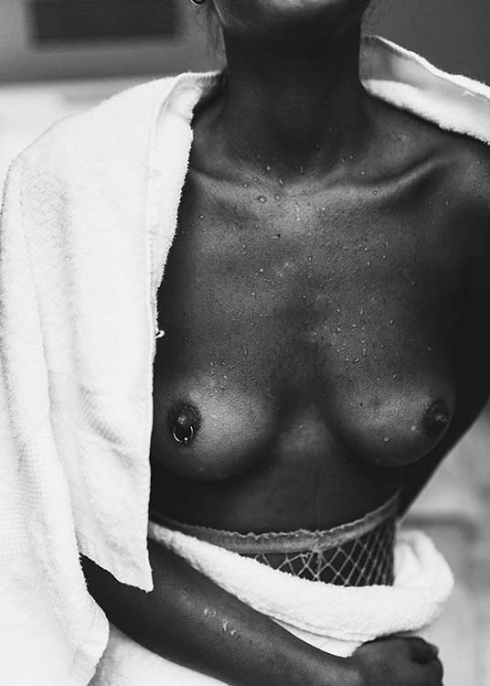 – Photo en noir et blanc d'une femme nue à partir de la taille, qui se sèche 