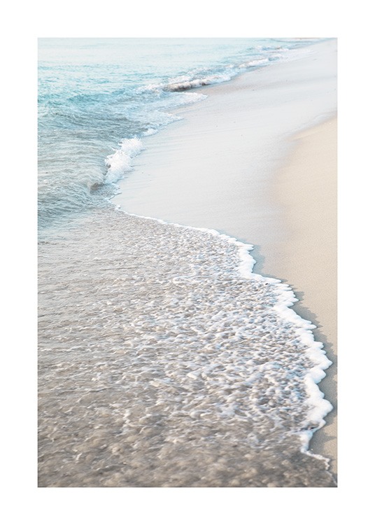  – Photographie d’une plage de sable clair avec des vagues s’échouant sur la plage