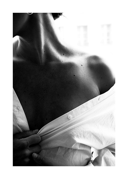  – Photographie en noir et blanc de l’épaule nue d’une femme portant une chemise blanche