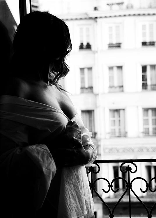 – Photographie en noir et blanc d''une femme debout près d''une fenêtre 