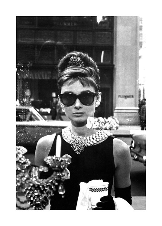  – Photographie en noir et blanc d’Audrey Hepburn portant des lunettes de soleil dans Diamants sur canapé