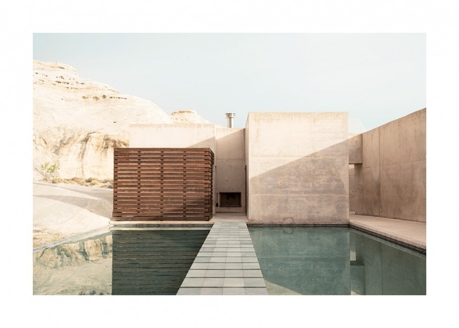 – Photographie d’un bâtiment en béton avec des montagnes à l'arrière-plan et une piscine au premier plan