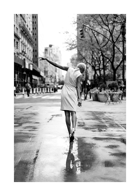 Femme portant une dans une rue  humide de New York avec la main tendue vers le haut