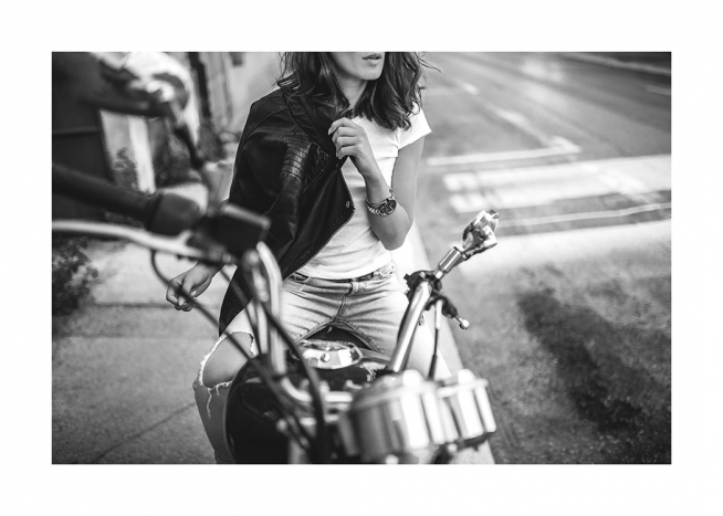 Photographie en noir et blanc d’une femme assise sur une moto et portant une veste de cuir