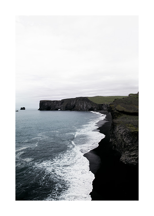  - Photographie de la côte avec des falaises noires, une plage noire et des vagues de l'océan