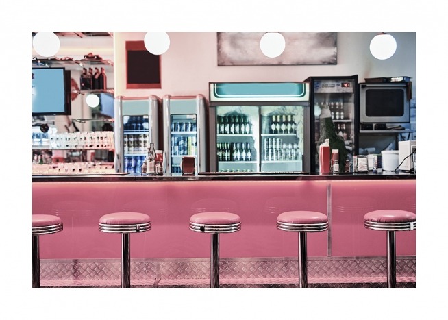  - Photographie d'un café-restaurant vintage avec des tabourets roses devant un comptoir rose