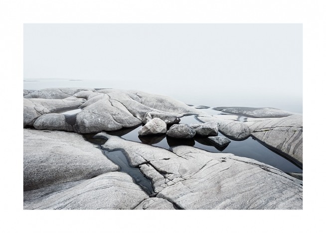  – Photographie d’un littoral avec des rochers lisses et de l’eau entre eux
