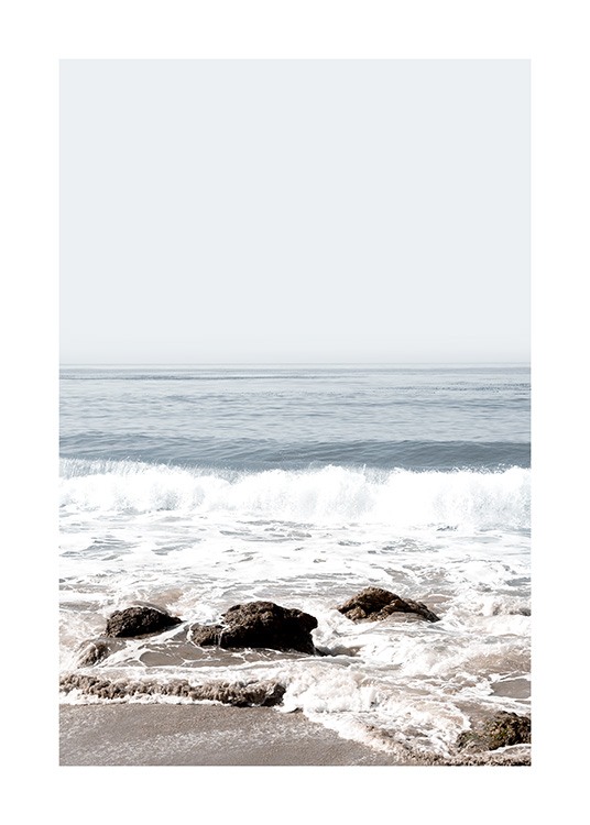  – Photographie de vagues s’échouant sur une plage avec des rochers