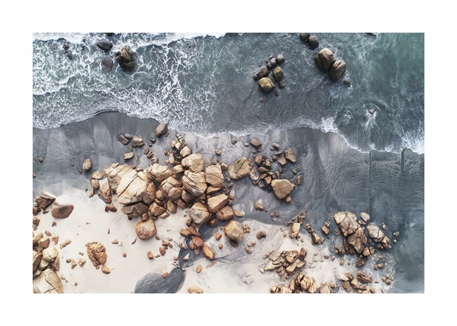  – Photographie au-dessus d’un bord de mer avec des roches et des rochers sur la plage
