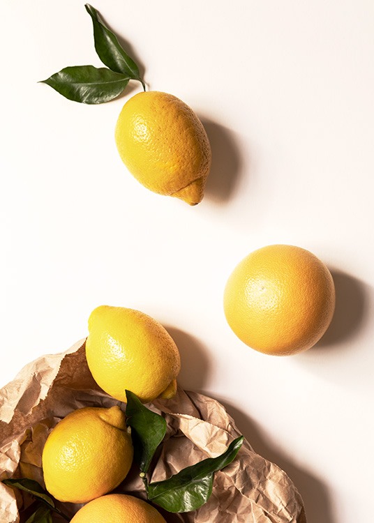 – Photographie de citrons, de feuilles vertes et d'un sac en papier sur un fond jaune clair