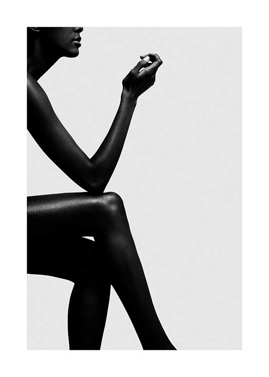  – Photographie en noir et blanc d’une femme assise avec son coude reposant sur son genou