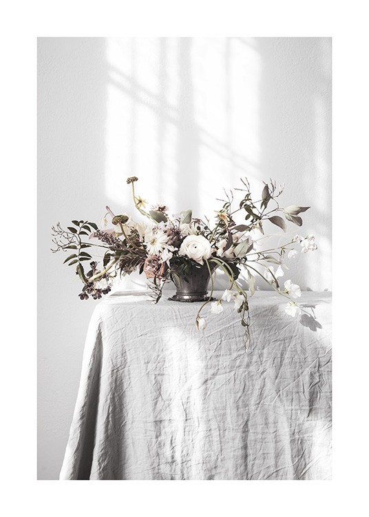 – Photographie d’un grand bouquet de fleurs et de feuilles vertes, sur une table avec une nappe