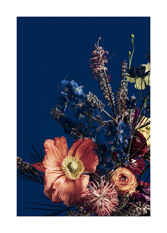  – Photographie de fleurs rouges et bleues dans un bouquet coloré, sur un fond bleu foncé