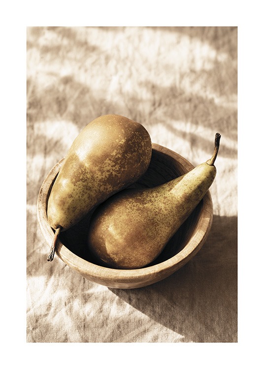  – Photographie de deux poires posées dans un bol en bois sur un tissu en lin beige