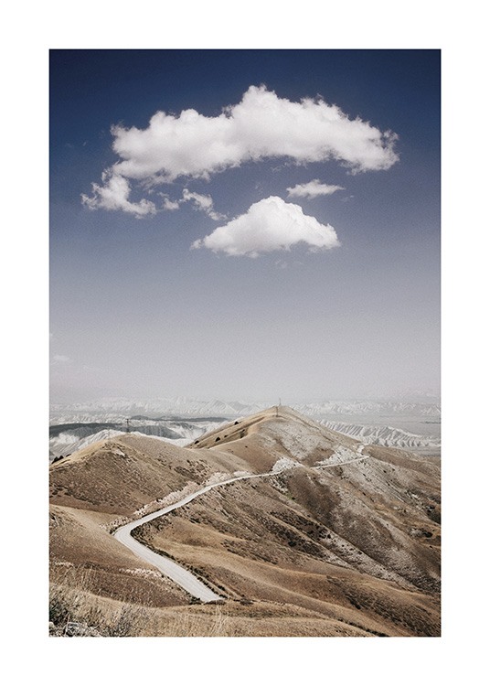  – Photographie d’une chaîne de montagnes avec une route qui passe à travers, avec des nuages et un ciel bleu à l’arrière-plan