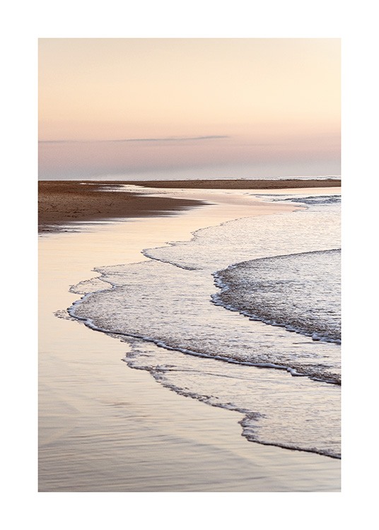  – Photographie de vagues immobiles s’écrasant sur une plage avec un ciel rose clair à l’arrière-plan