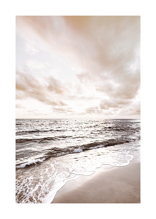  – Photographie d’un océan calme avec une plage au premier plan et des nuages à l’arrière-plan