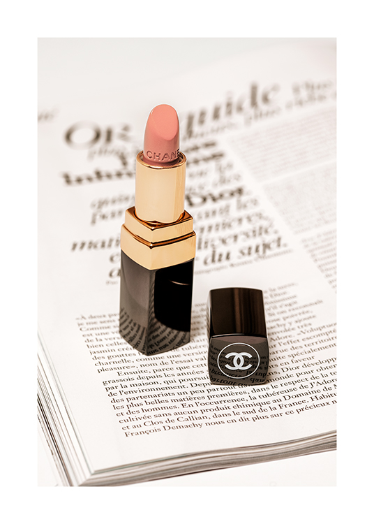  – Photographie d’un rouge à lèvres Chanel rose clair avec une page de livre en dessous