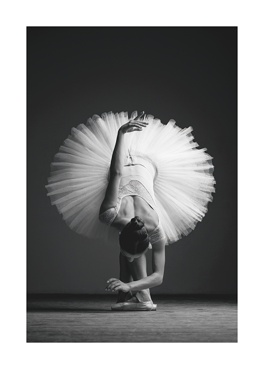  – Photographie en noir et blanc d’une ballerine penchée en avant dans une jupe en tulle