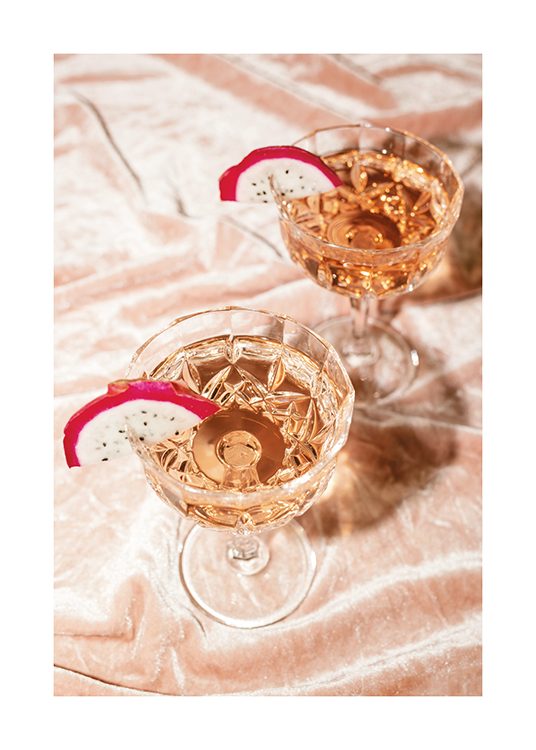  – Photographie de deux cocktails au champagne rosé dans des verres en cristal avec des tranches de fruit du dragon
