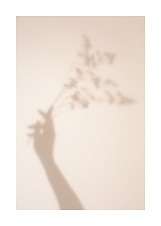  – Photographie de l’ombre d’une main et de fleurs sur un fond beige clair