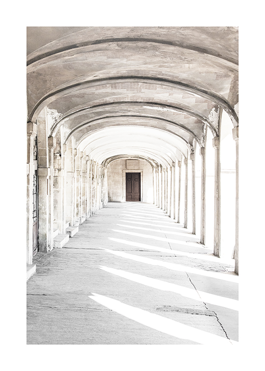  – Photographie d’un couloir en forme d’arche avec une porte à l’extrémité et des piliers sur les côtés