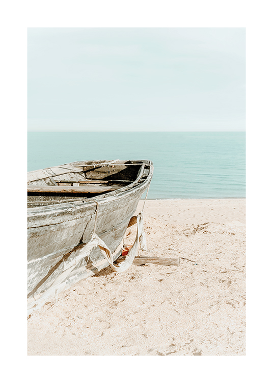 – Photographie d’un vieux bateau dans le sable sur une plage avec le ciel et l’océan à l’arrière-plan