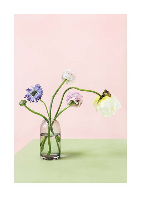 – Photographie de fleurs colorées dans un vase sur une table verte,