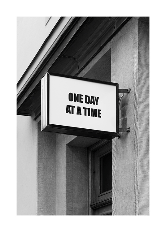  – Photographie en noir et blanc d’une enseigne avec du texte sur un bâtiment