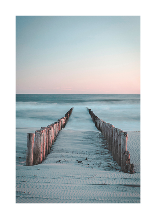  – Photographie de deux rangées de poteaux en bois allant de la plage à l’océan couvert de brouillard
