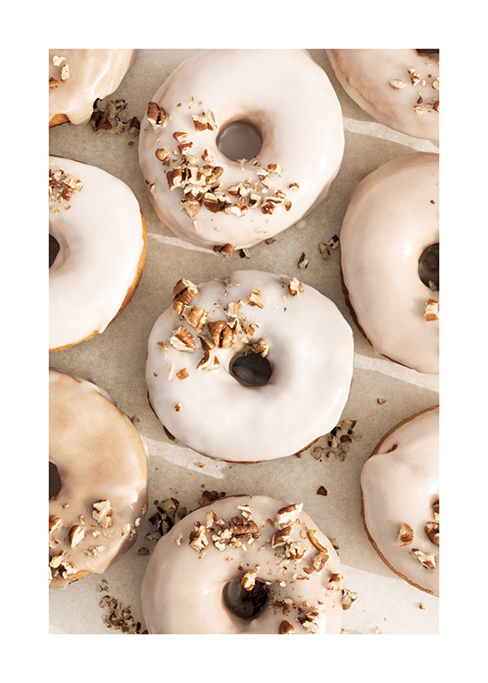  – Photographie d’un groupe de donuts avec glaçage beige et blanc et éclats de noisettes