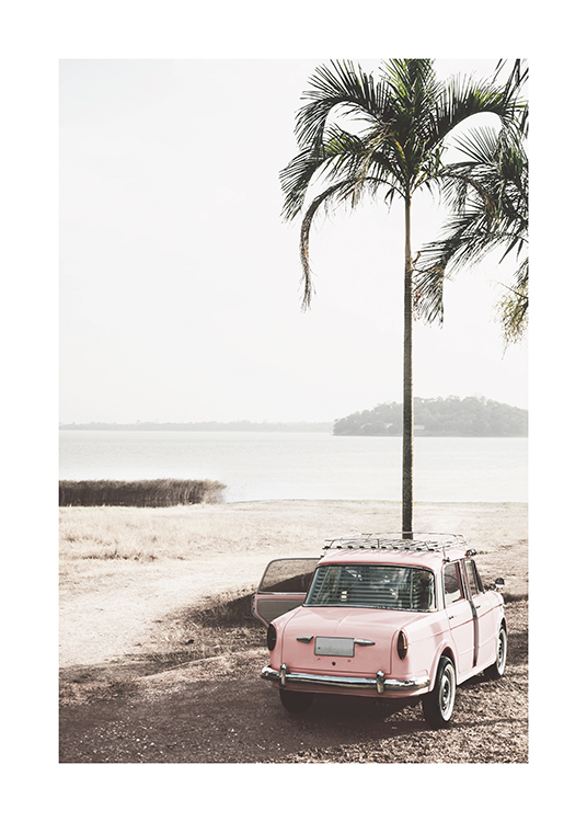  – Photographie d’une voiture ancienne en rose garée à côté d’un palmier sur une plage