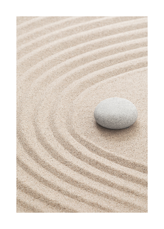  – Photographie de sable avec des sillons et un caillou gris posé dessus