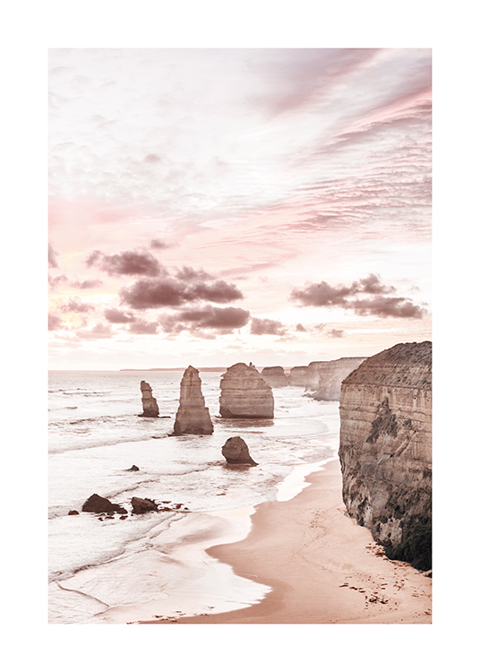  – Photographie de falaises au bord de l’océan avec un ciel rose pastel derrière les falaises