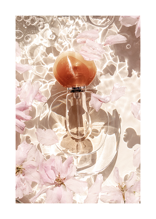  – Photographie d’un flacon de parfum entouré de fleurs et de pétales roses dans l’eau