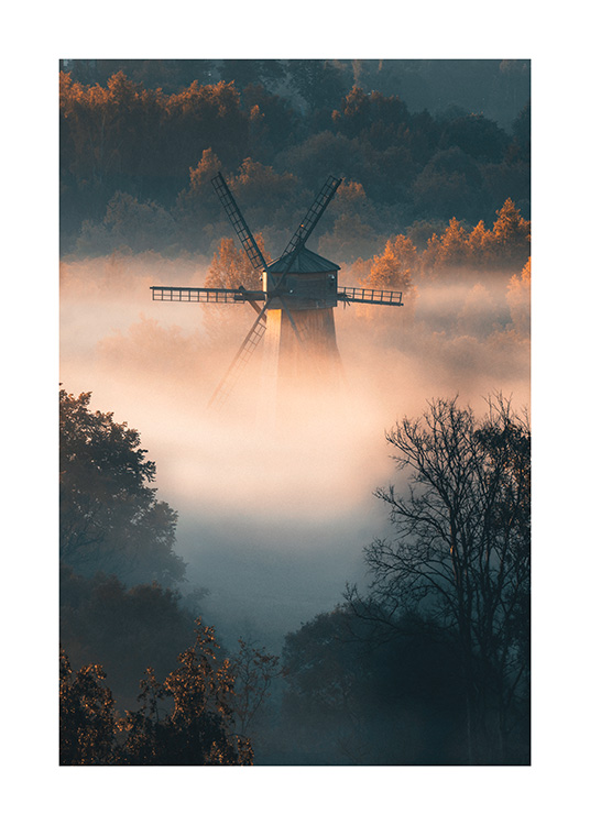  – Photographie d’une forêt brumeuse avec un moulin à vent sous le brouillard, avec la lumière du soleil qui brille sur la forêt