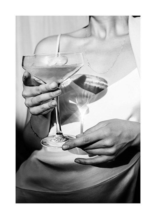  – Photographie en noir et blanc d’une femme tenant une coupe de champagne