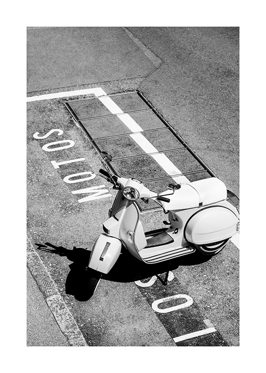  – Photographie en noir et blanc d’un scooter rétro sur un parking avec du texte écrit sur le sol