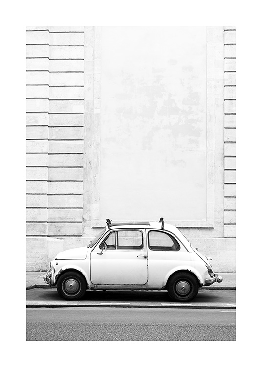  – Photographie en noir et blanc d’une petite voiture ancienne garée devant un bâtiment avec un effet strié