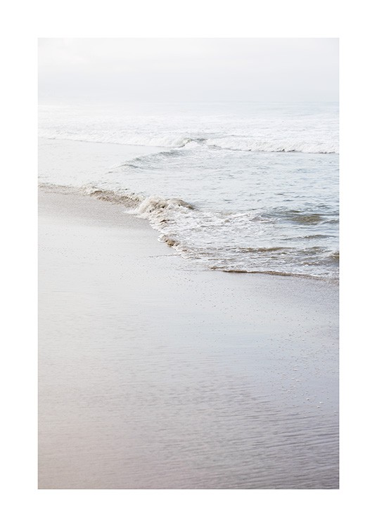  - Photographie d'une plage au bord de mer calme avec une petite vague